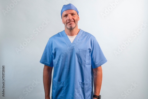 Portrait of a physiotherapist in light blue gown looking at camera in studio.