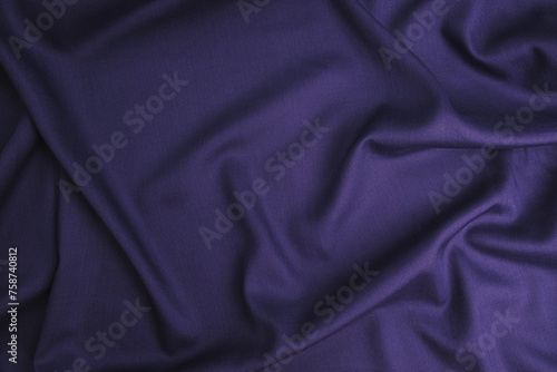 Texture of cotton fabric in oriental blue-purple color, top view. Background, texture of draped fabric without patterns..