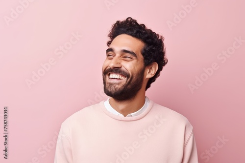 Portrait of a happy young man in a pink sweater on a pink background