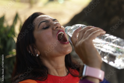 Portrait of woman drinking water from a plastic water bottle. lady feeling fresh, refresh drink, wellness, healthcare, mineral, Healthy lifestyle.