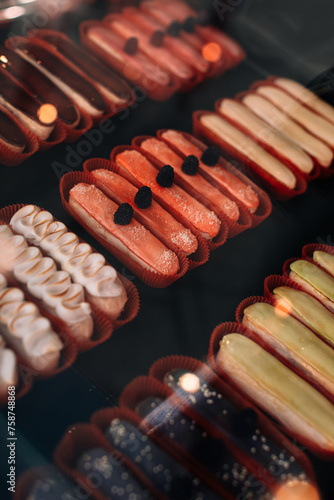 Assortment of delicious sweet berry eclairs with cream on the counter of a baking store or coffeeshop