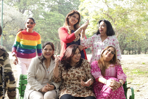 Reunion of happy Indian women. green park lush green atmosphere. tranquil and serene environment. elderly old friends together. three women in park having fun in day time. ladies enjoying.