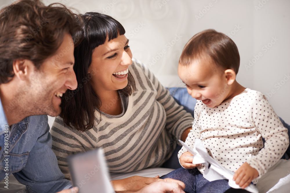 Parents, toddler and tablet for laugh in home, online and happy for funny cartoon in bedroom. Family, child development and girl for streaming entertainment, website and app for series or movie Parents, toddler and tablet for laugh in home, online and happy for funny cartoon in bedroom. Family, child development and girl for streaming entertainment, website and app for series or movie