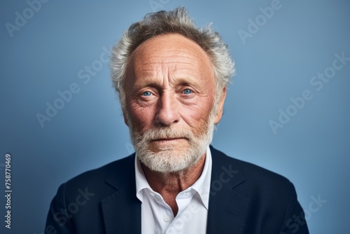 Portrait of senior man with grey hair and beard. Isolated on blue background.