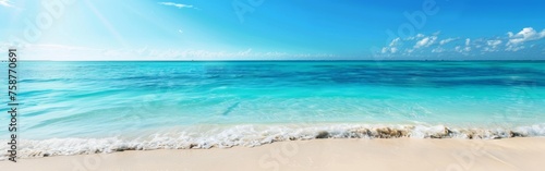 A sandy beach under a blue sky with fluffy white clouds, leading towards crystal clear blue water. The scene is serene and inviting, with gentle waves lapping at the shore.