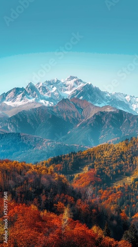 A breathtaking view of a vast mountain range in autumn, showcasing vibrant fall colors on the trees and bushes. The mountains loom tall in the background under a clear sky.