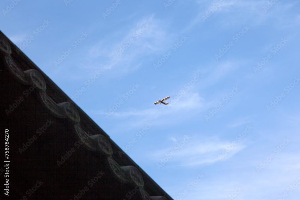 Fototapeta premium View of a flying airplane against the blue sky