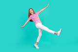 Full size photo of pretty teenager girl falling down fly walk dressed stylish pink print outfit isolated on aquamarine color background