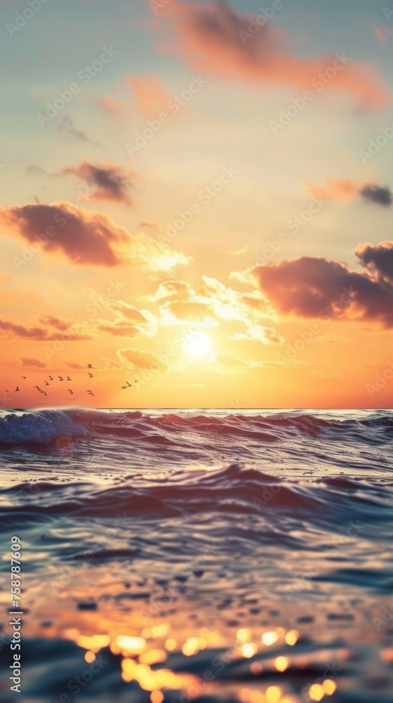 The sun is seen lowering on the horizon, casting a warm golden light over the rolling ocean waves. The sun is seen lowering on the horizon, casting a warm golden light over the rolling ocean waves.