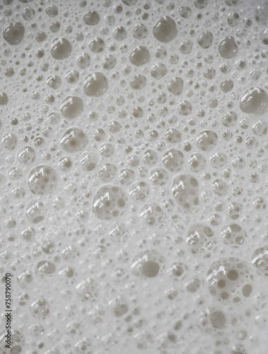 Image of drops of cream colored liquid on a white space.