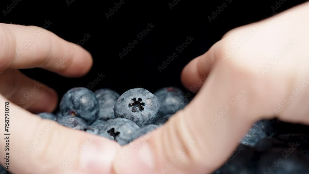 Male hands gather blueberries from both sides and scatter the berries, close-up, slow motion.