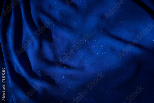 Blue fabric. Blue background. Fabric texture. Sparkles. Luxurious textiles. Waves