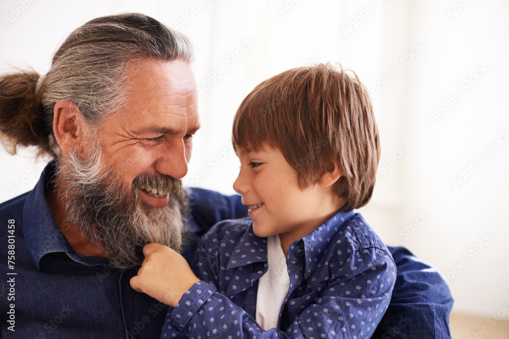 Smile, grandfather and boy with beard and playing, bonding and relax in living room. Happy family, play and fun with grandpa and pulling facial hair, embrace and caring cuddle with love in lounge Smile, grandfather and boy with beard and playing, bonding and relax in living room. Happy family, play and fun with grandpa and pulling facial hair, embrace and caring cuddle with love in lounge