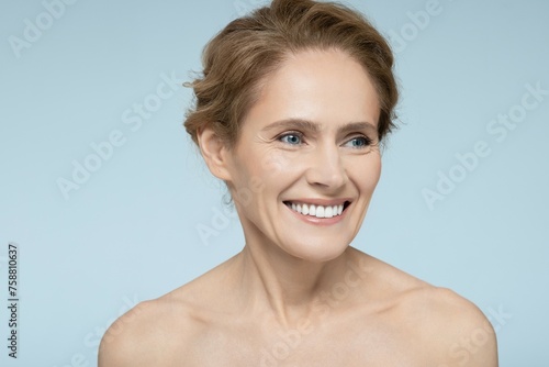 Portrait of beautiful woman with clean, healthy skin and natural make-up isolated on blue background. Perfect female face, skin care