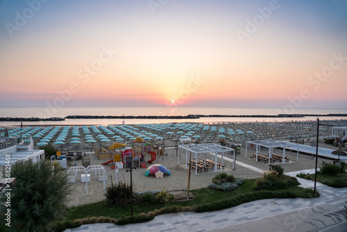 Obraz na płótnie Beautiful sunrise on Rimini beach with umbrellas w salonie