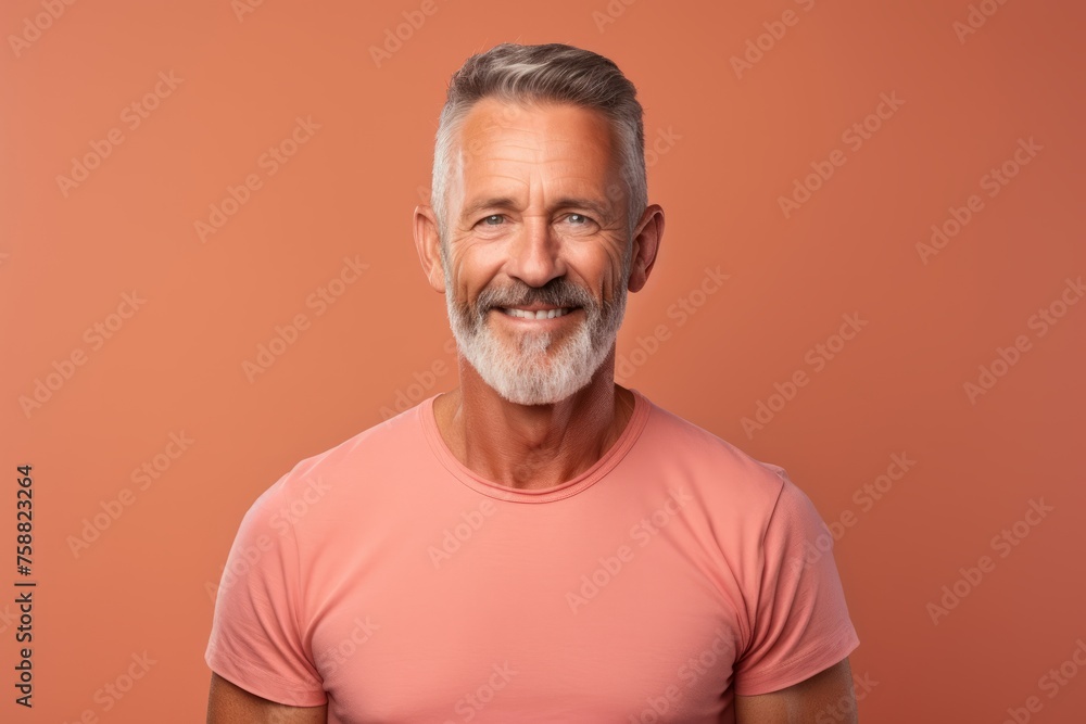 Portrait of smiling senior man in casual t-shirt. Isolated on orange background. Portrait of smiling senior man in casual t-shirt. Isolated on orange background.