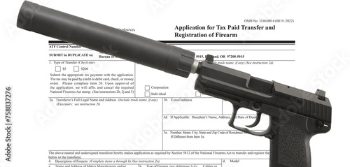 Semi automatic handgun with silencer in front of ATF public domain tax form photo