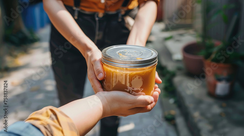A person is holding a glass jar filled with food in their hand