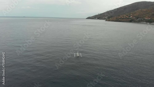 Aerial view of coastline with fishing boat floating at calm sea, Amed, Bali, Indonesia photo