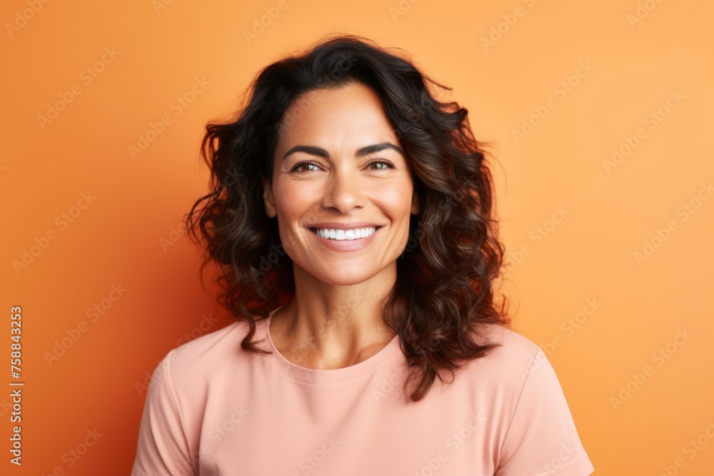 Portrait of a happy young woman looking at camera over orange background Portrait of a happy young woman looking at camera over orange background