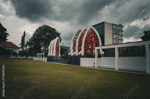 gate with white traditional house roof and red cloth motif in Mataram city center park photo