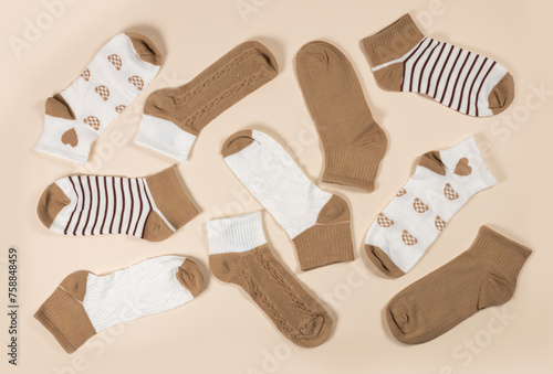 Multi-colored socks on a beige background. View from above. Many different socks for cold seasons.