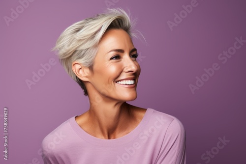 Portrait of a smiling middle aged woman with short blond hair on purple background