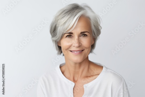 Portrait of smiling senior woman looking at camera, over grey background