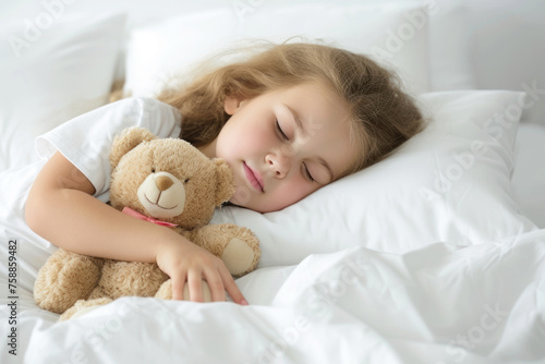 Cute little girl sleeping in bed with teddy bear, isolated on white