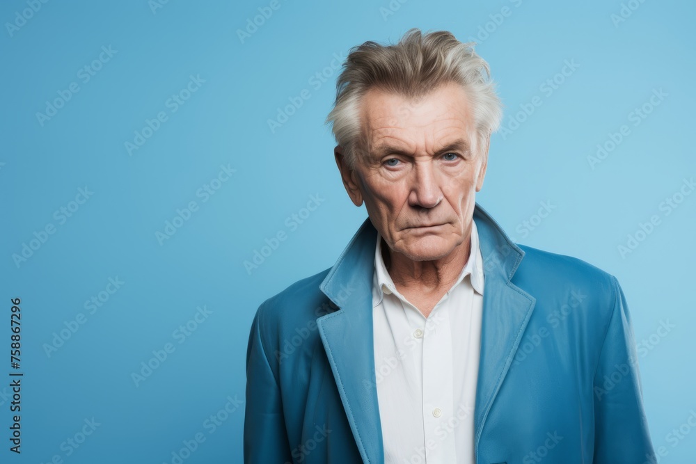 Portrait of angry senior man looking at camera isolated on blue background Portrait of angry senior man looking at camera isolated on blue background