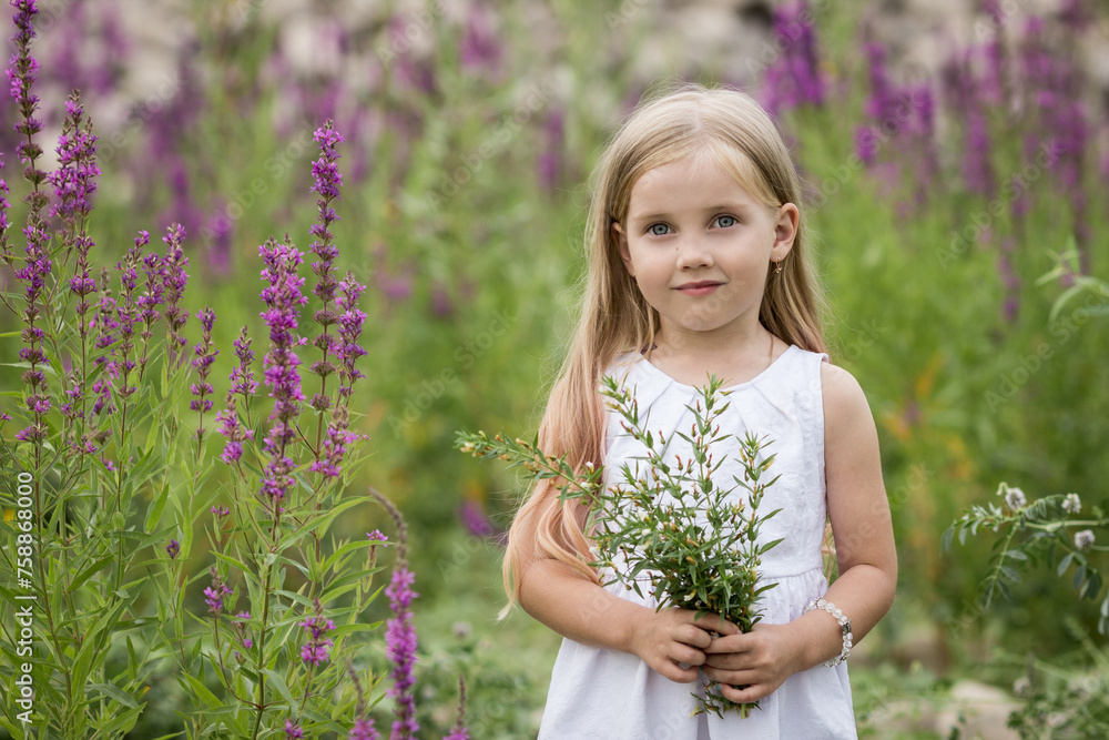Blonde girl in a white dress holds flowers in her hands Blonde girl in a white dress holds flowers in her hands