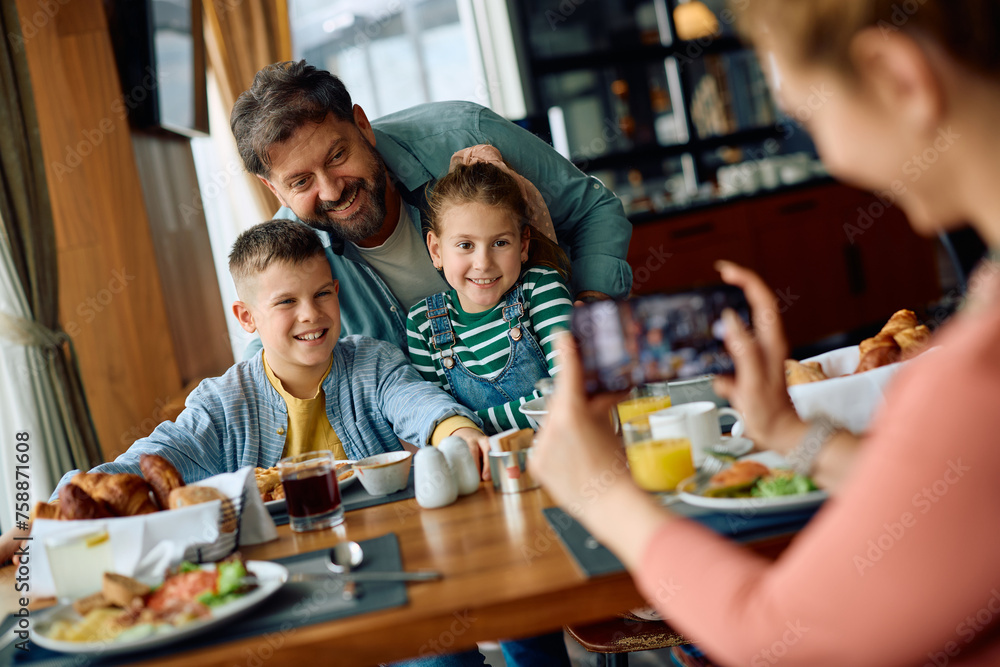 Happy family having fun while being photographed during breakfast in hotel restaurant. Happy family having fun while being photographed during breakfast in hotel restaurant.