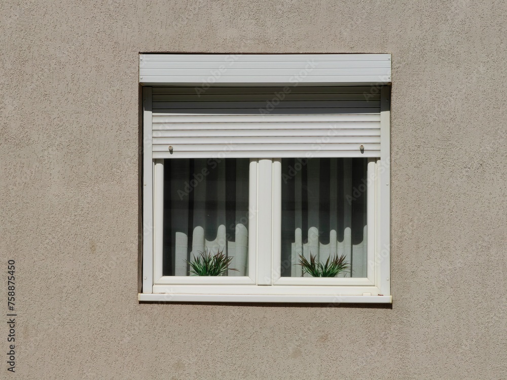 Fototapeta premium Symmetrical elegance. White blinds, window curtains and flower pots. Light and shadow. Pattern and texture. Wall background.