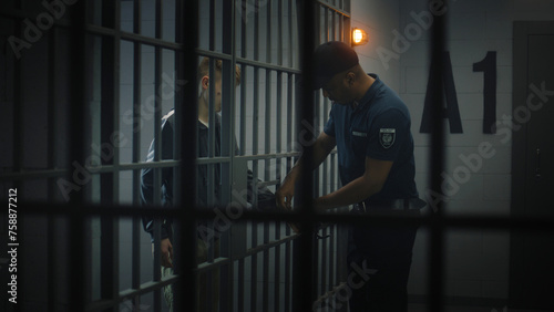 Фотография Warden takes off handcuffs from young prisoner
