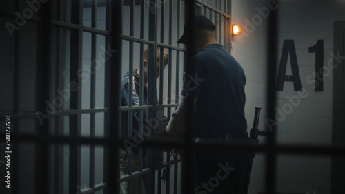 Fotografie Warden takes off handcuffs from young prisoner