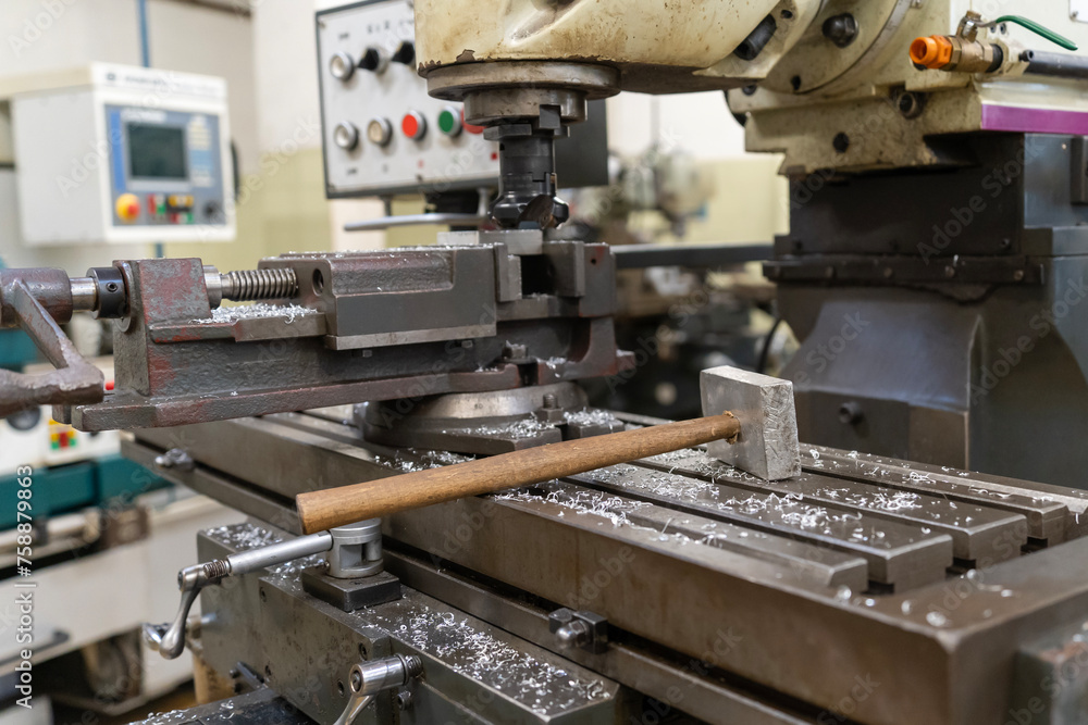 Metal working milling machine with a hammer in a workshop