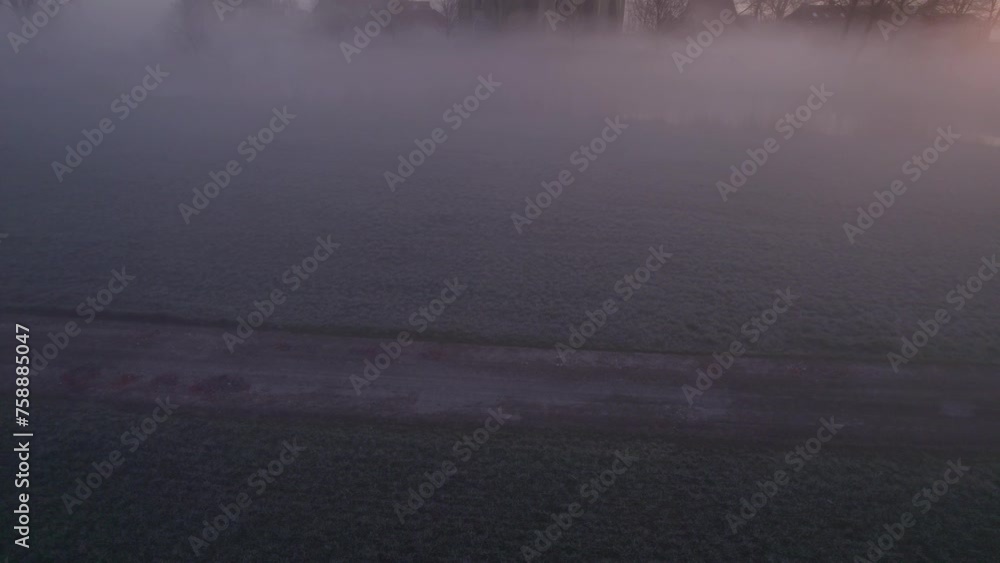 Aerial view of church (Kerk van Hichtum) in small town during foggy sunrise, Hichtum, Netherlands