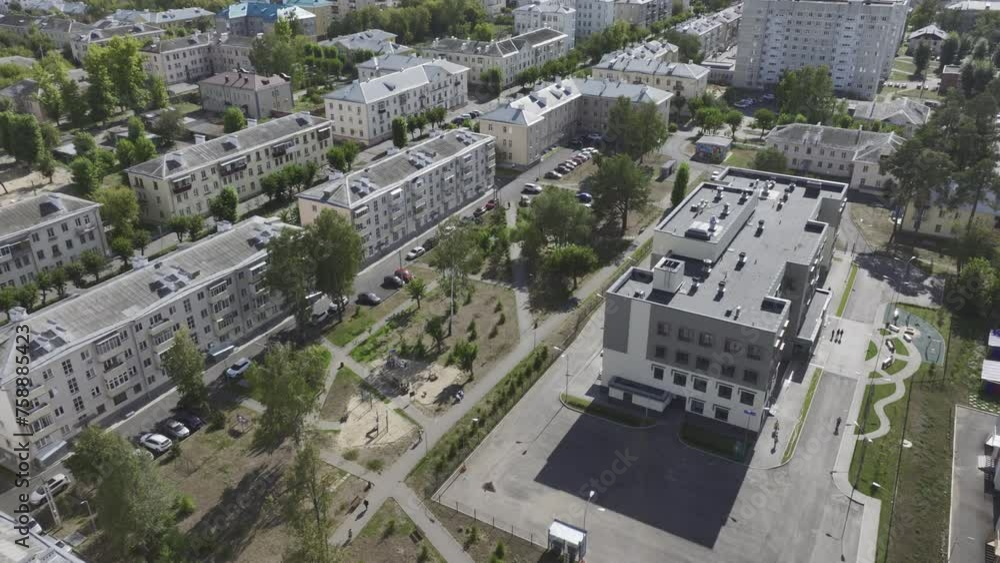 Neatly aligned residential buildings stand in rows. Pedestrians walk along tree-lined streets enjoying scenic views of urban architecture Neatly aligned residential buildings stand in rows. Pedestrians walk along tree-lined streets enjoying scenic views of urban architecture