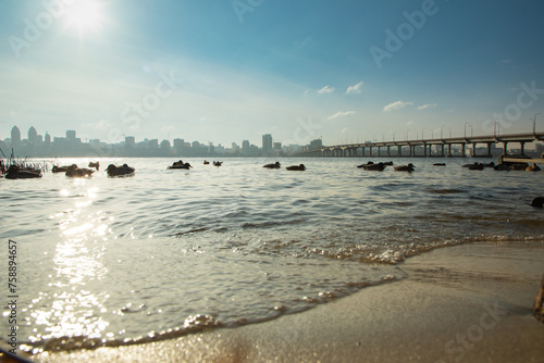 Dnipro river, Dnipro city, Ukraine. Cityscape with blue sky with clouds and river, and city buildings. photo