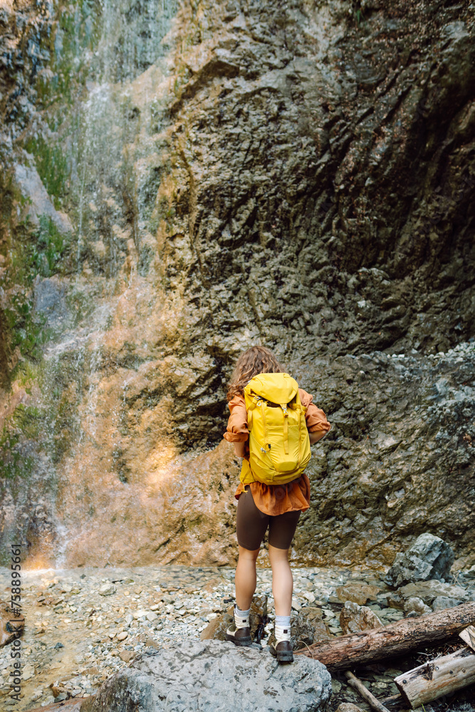 Young woman with backpacks and walking sticks hiking in nature. Adventure, travel, tourism, hike and people concept.