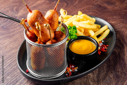 corn dog with mustard sauce and french fries on plate