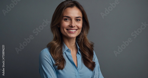 Happy young smiling confident professional business woman wearing blue shirt, pretty stylish female executive looking at camera, standing arms crossed isolated at gray background