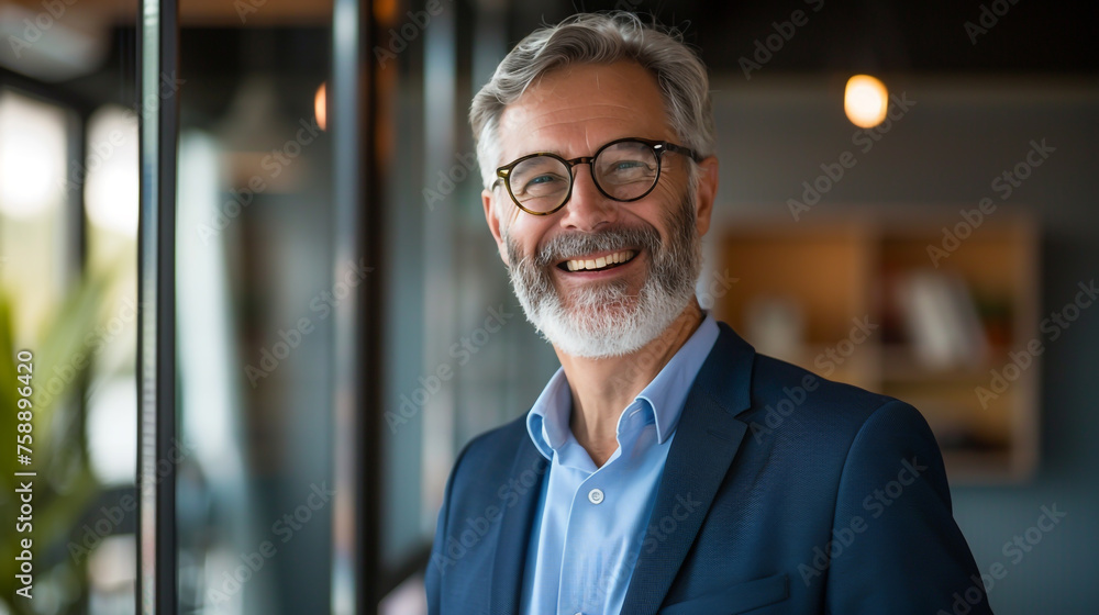 A poised 50-year-old executive, manager, and investor smiling confidently for a portrait in his office. A poised 50-year-old executive, manager, and investor smiling confidently for a portrait in his office.
