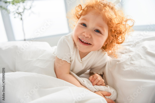 Wallpaper Mural Redhead girl on the bed rests and plays. Cute little girl Torontodigital.ca