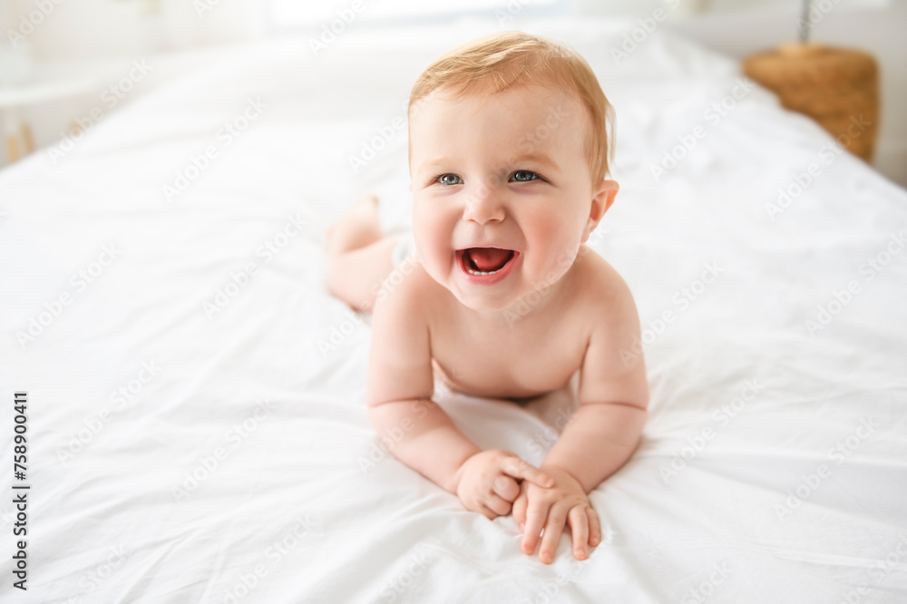 Baby boy in diaper on white sunny bedroom. one years child relaxing in bed. Baby boy in diaper on white sunny bedroom. one years child relaxing in bed.