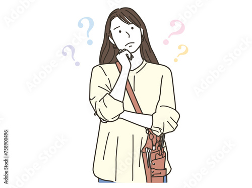 悩むポーズをする若い女性の美容師