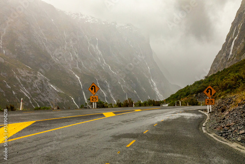 Water from torrential rain and snow-melt rushes down steep rockfaces toward a hairpin turn on State Highway 94, in Fiordland, New Zealand, the road to Milford Sound