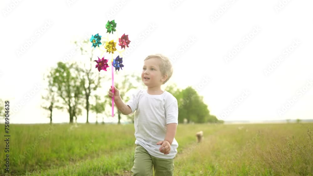 baby boy playing with spinner toy in the park. happy family lifestyle kid dream concept. baby a son plays with a toy windmill outdoors in the forest in summer baby boy playing with spinner toy in the park. happy family lifestyle kid dream concept. baby a son plays with a toy windmill outdoors in the forest in summer