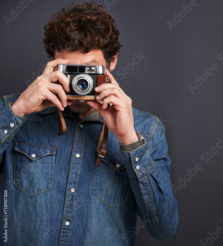 Vintage, fashion or photography by man, camera lens or capture of creative, graphic or style. Male photographer, film or retro gadget as trendy, denim or urban outfit in studio on grey background