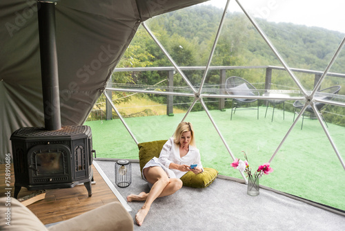 woman with smartphone in dome tent